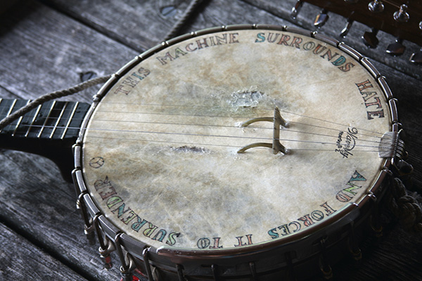 "This Machine Surrounds Hate and Forces It to Surrender," imprinted on Pete Seeger's banjo